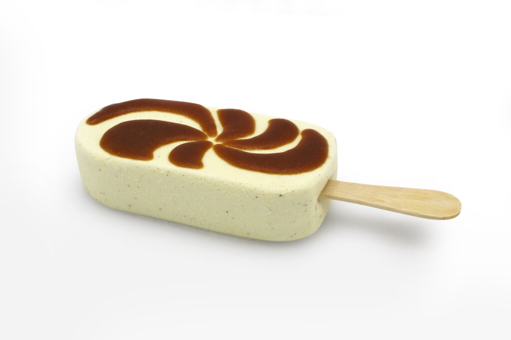Ice cream bar on a stick with a spiral swirl of caramel deposited on top