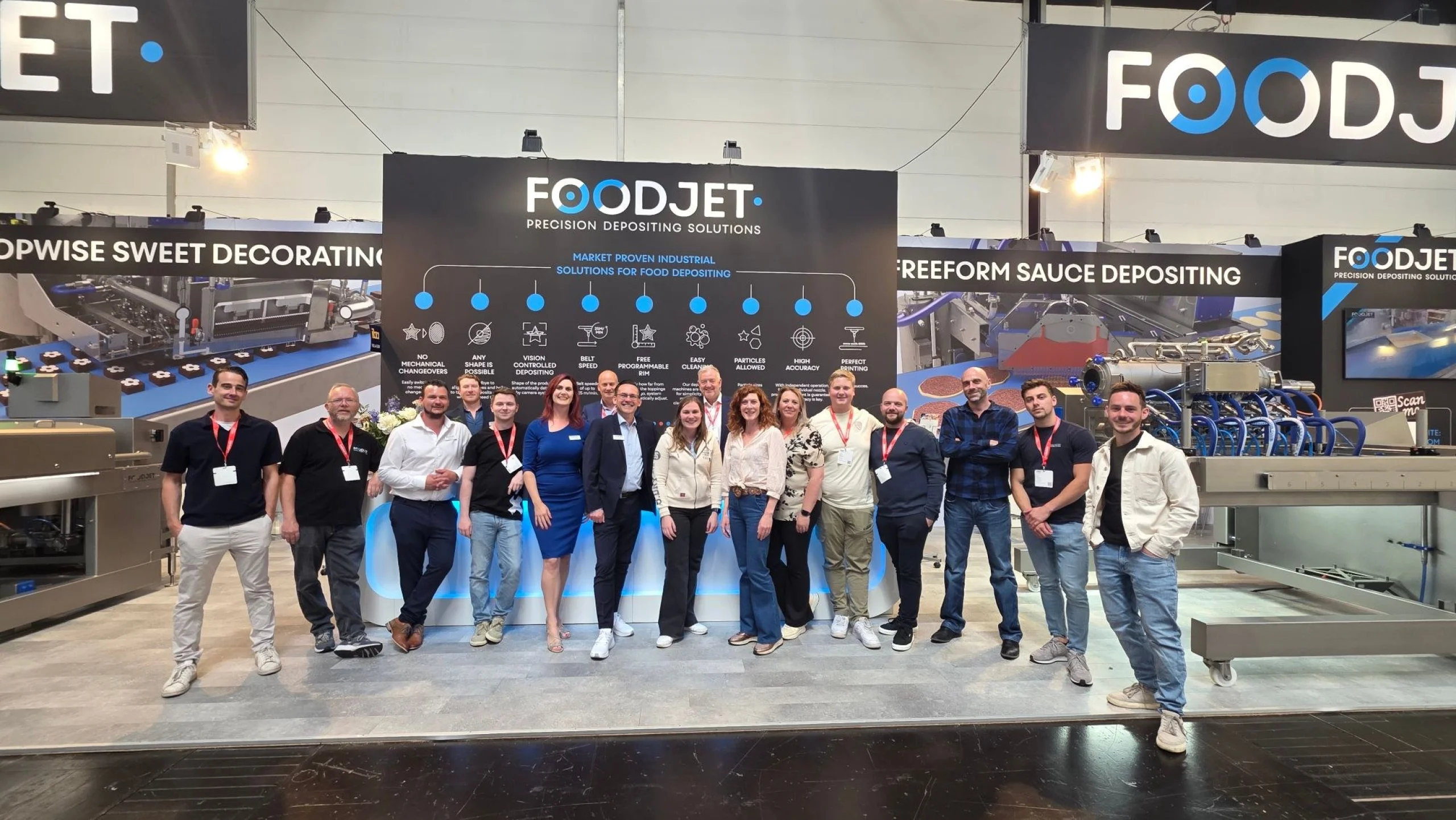 The FoodJet team standing in front of the reception desk on the stand at iba 2025